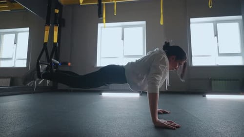 Crossfit Fitness TRX Training Exercises at Gym Woman Pushup Workout