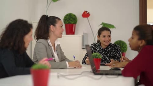 Businesswomen Collaborating at Meeting Table in Bright Office