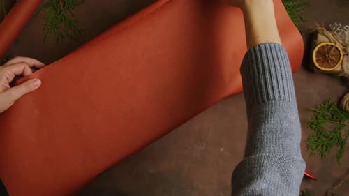 Wrapping Christmas Present With Red Paper Overhead