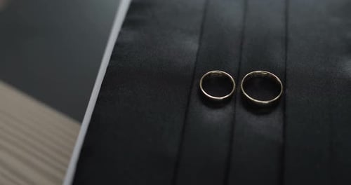 Close Up of Gold Wedding Rings on Black Surface