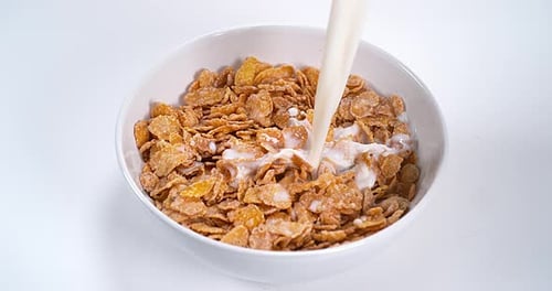 Milk Pouring into Bowl of Corn Flakes Cereal