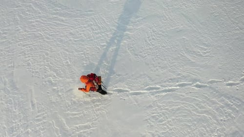 Footage a Lone Traveler with a Backpack Walks Through the Snowy Desert