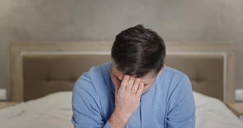L'homme a appris que la mauvaise nouvelle enlève ses lunettes, déçue, tient sa tête, ressent le désespoir et