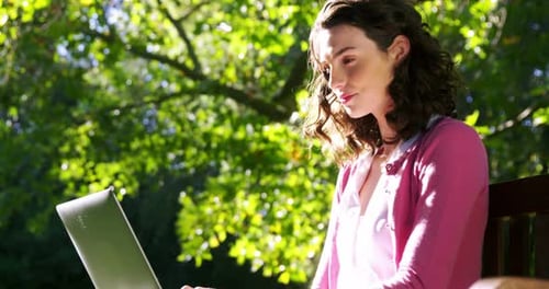 Beautiful woman using laptop in garden