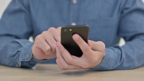 Primer plano de las manos masculinas con un teléfono inteligente