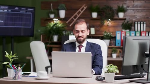 Porträt eines jungen gutaussehenden Geschäftsmannes, der am Laptop