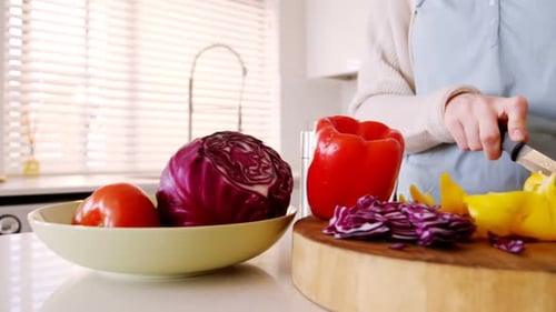 Adult Preparing Vegetables in a Sunny Kitchen