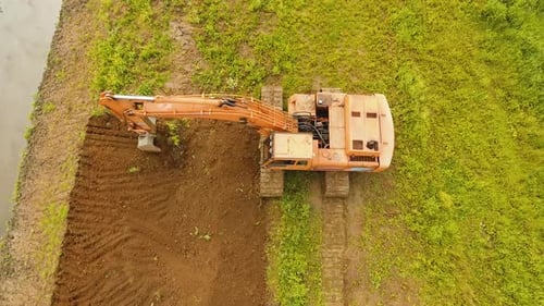 Excavator Digging a Trench in the field.Aerial Video.