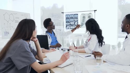 Professional Doctors Discussing X-ray Prints of Patient in the Clinic