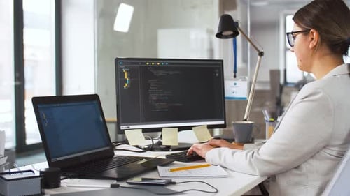 Woman Typing Code at Office Computer