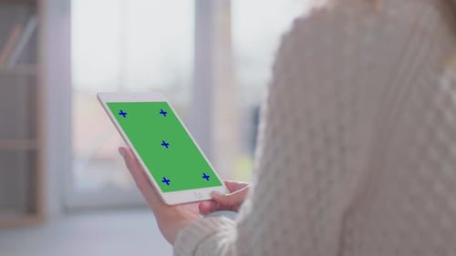 Woman holds tablet with chroma key screen