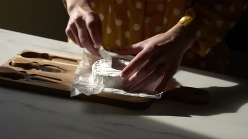 Cutting Wheel of White Cheese on Wooden Board
