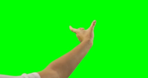 Person making hand gesture against green screen background
