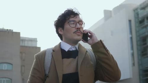 Businessman Talking on Smartphone at Street. Professional Walking with Phone