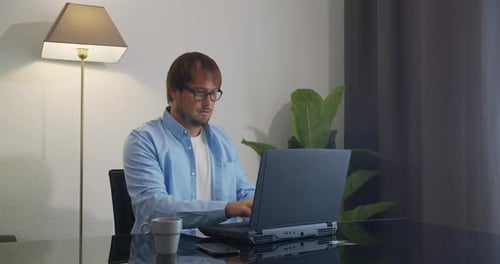Man Working on Laptop at Desk Indoors