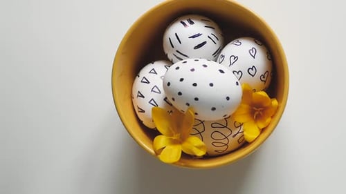 Decorated Easter Eggs in a Yellow Bowl