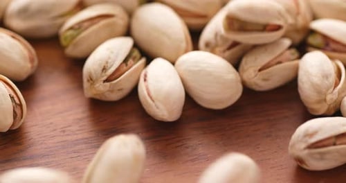 Close up of pistachios on a wooden surface