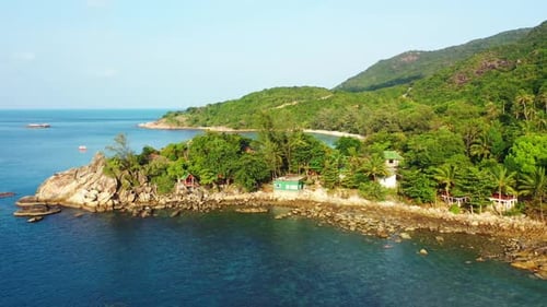 Aerial drone shot scenery of perfect shore beach vacation by blue green lagoon and white sandy backg
