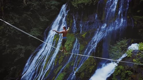 Fit Man High-lining Over A Waterfall