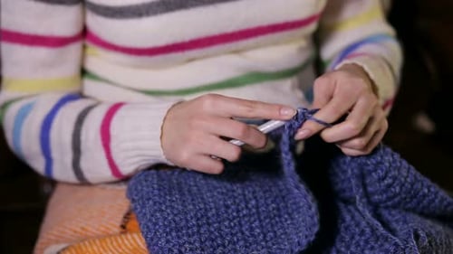 Woman Hand Crocheting with Hook and Blue Yarn