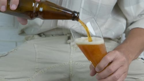 Un homme verse de la bière dans un verre.