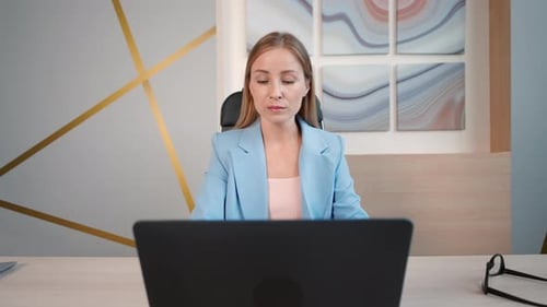Woman Closing Laptop and Relaxing in Office