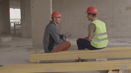 Construction Workers Talking in Unfinished Concrete Building