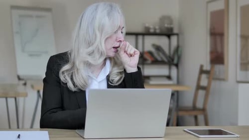 Woman Coughing While Working at Laptop in Office