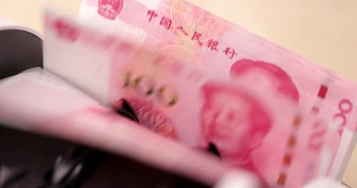 Money Counting Machine Processes Pink Renminbi Banknotes