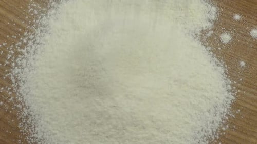 White Flour Being Poured on Wood Surface
