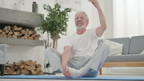 Senior Man Stretching at Home on Exercise Mat
