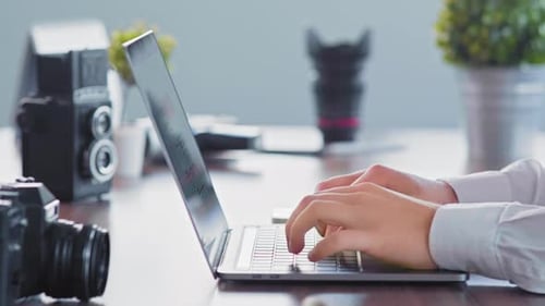 Hands Typing on Laptop at Bright Desk