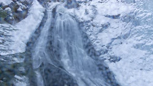 Snowy Waterfall Cascading Down a Rocky Mountain