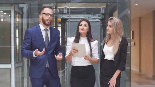 Portrait of Young Business People Talking in Lobby of Office Building