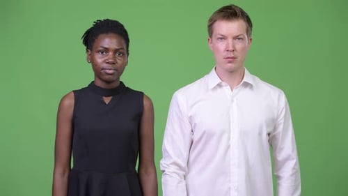 Dos jóvenes parejas de negocios multiétnicas con los brazos cruzados