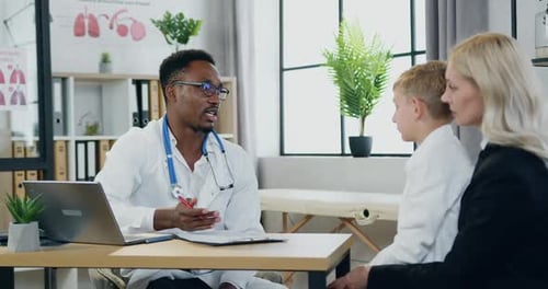 Mother with Handsome Son Visiting Local Doctor at Private clinic