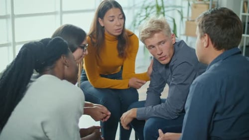 A Group Of People Sitting in a Circle During a Group Therapy Session