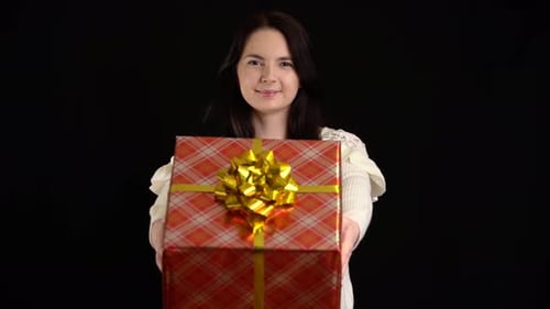 Woman Presents a Gift Wrapped in Red Plaid