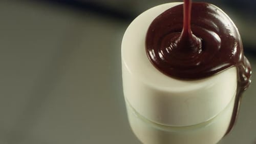 Tasty Cake in White Glaze Pouring with Hot Chocolate at Professional Kitchen.