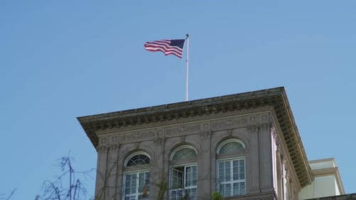 American Flag Flying Over City Building
