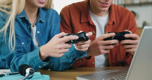 Pareja jugando Vídeo con palancas de mando sosteniendo un conjunto de ocio en casa