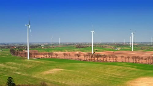 Flying above big wind turbines in a field, Poland