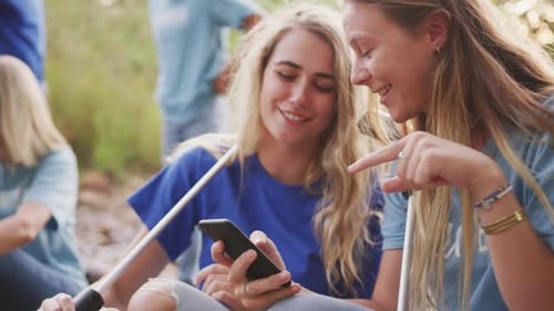 Mid adults volunteering and women laughing during river clean-up day