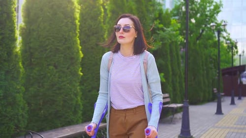 Beautiful Stylish Positive Young Woman with Injury on Crutches Walking Down the Street Sunny
