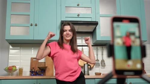 Woman Dancing and Recording Herself on Smartphone in Kitchen