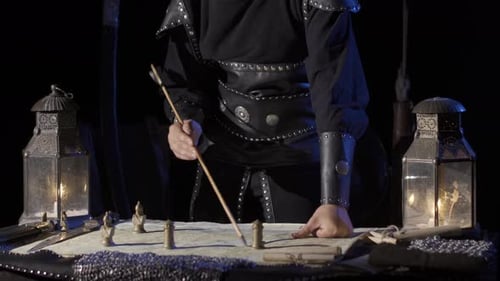 Medieval Strategist Planning with Map and Figurines