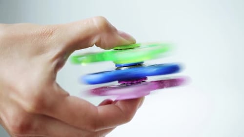Jouer à la main avec trois Fidget Spinners