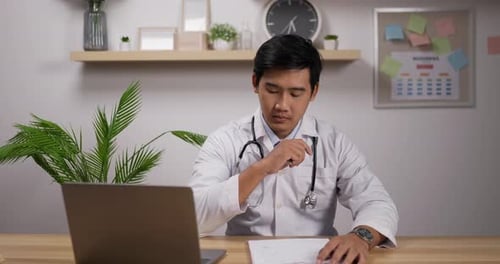 Male doctor cardiologist wearing white medical coat and stethoscope working in clinic
