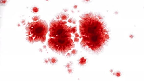 Red Ink Splatter Spreading on White Surface