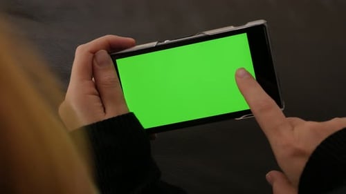 Inhalte scrollen auf dem Greenscreen-Display des Mobiltelefons 4K 2160p UHD-Video - Frau hält Smartphone
